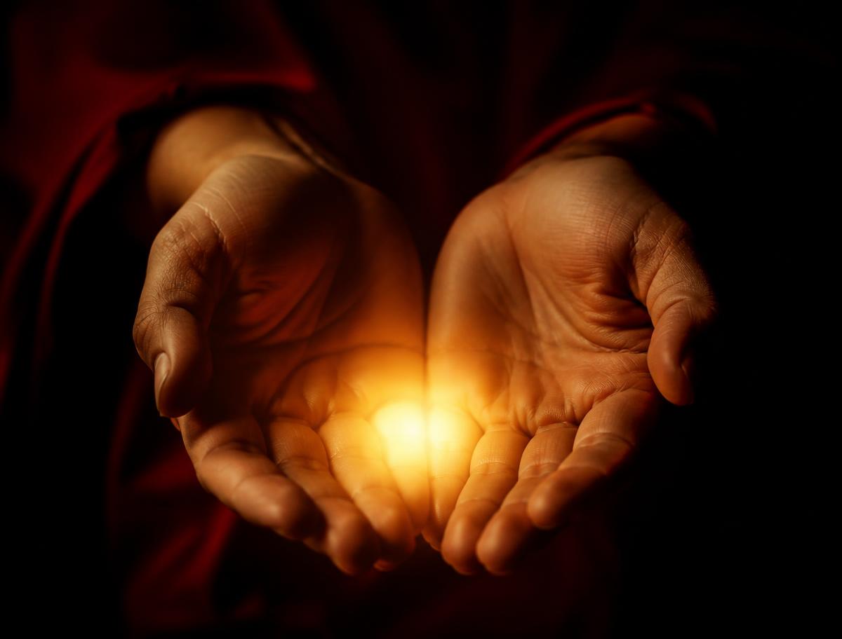 Hands holding a small warm light